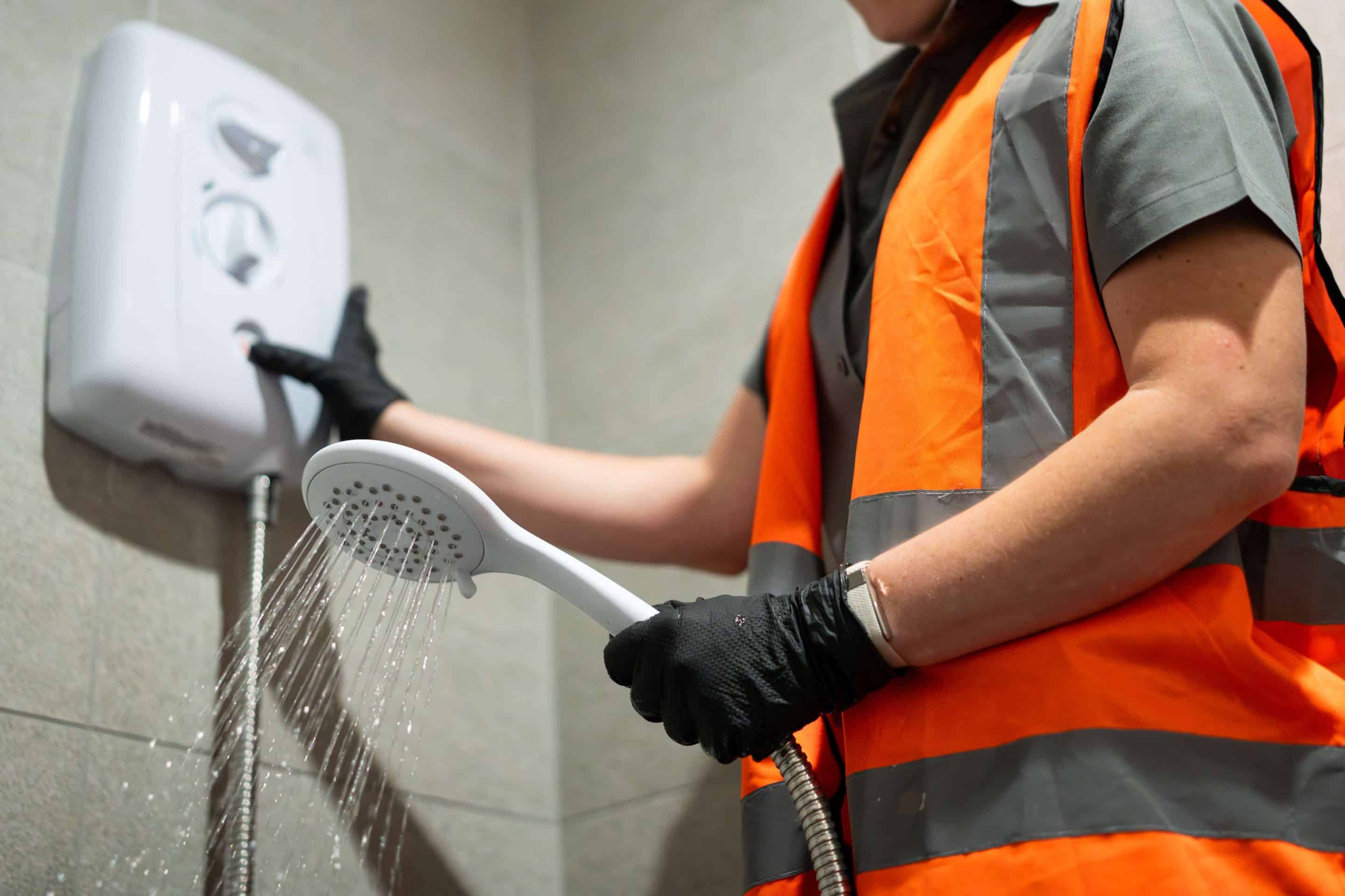Primary Water Solutions technician flushing an electric shower after cleaning